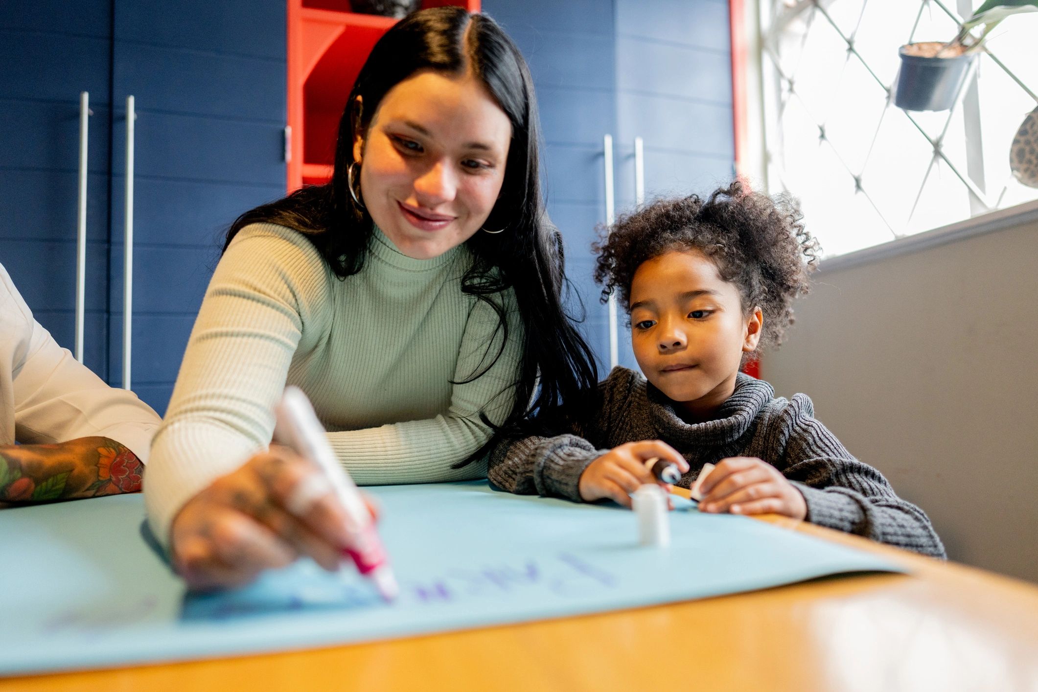 Parent helping a child with drawing and learning activities